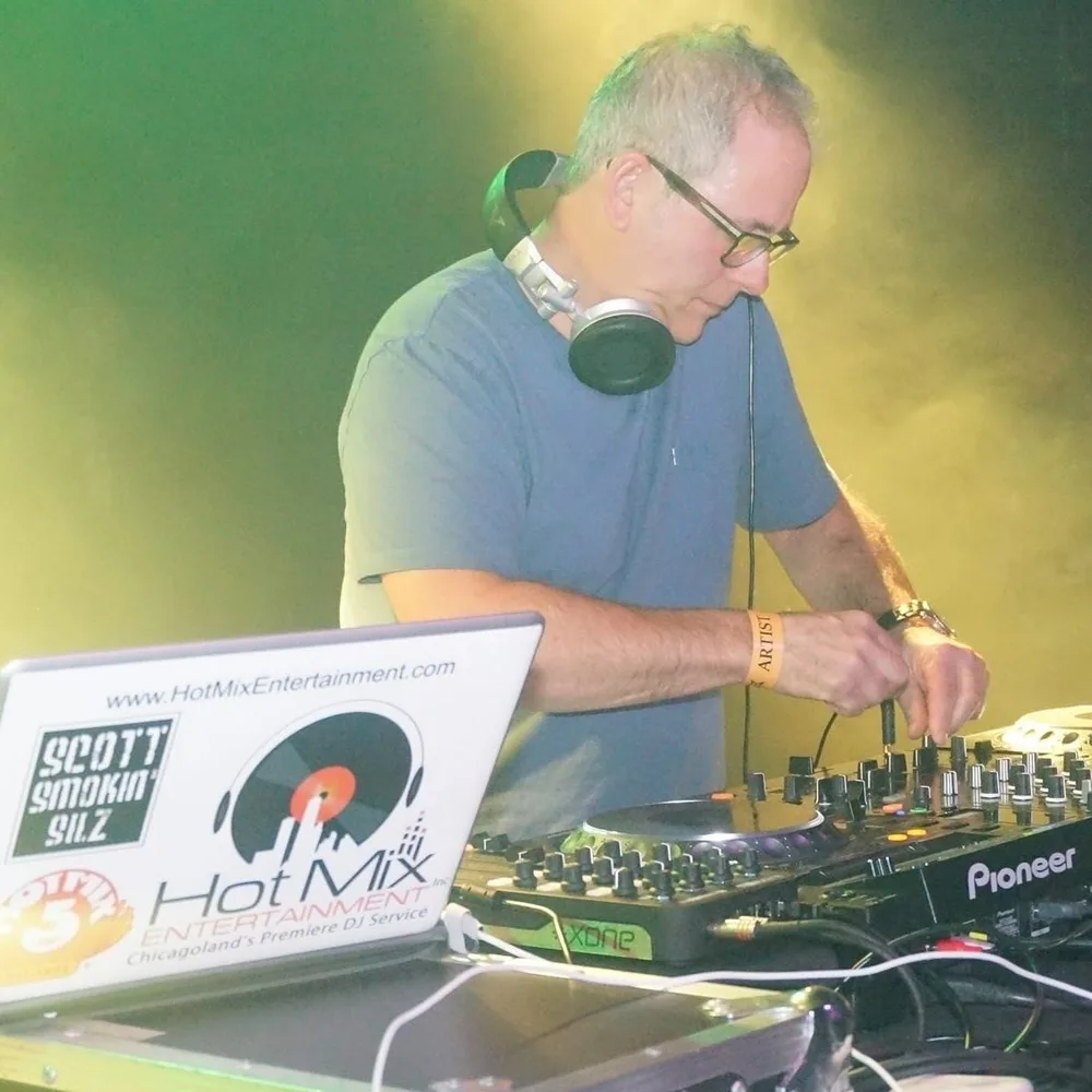 Scott Smokin Silz mixing on Pioneer equipment under yellow and green stage lighting