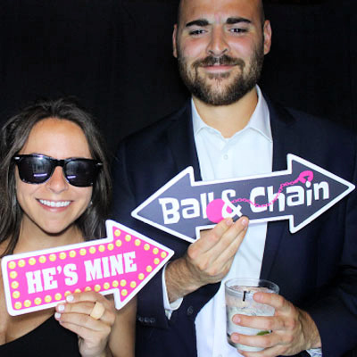 Couple at photo booth with wedding props