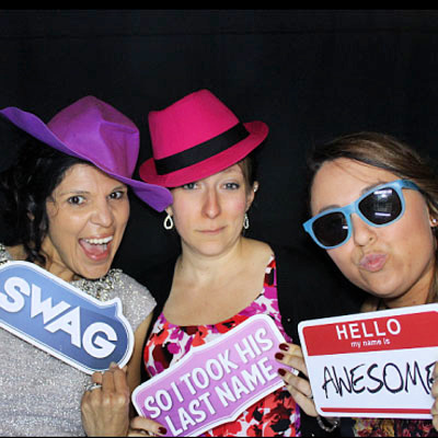 Three women at photo booth with fun props