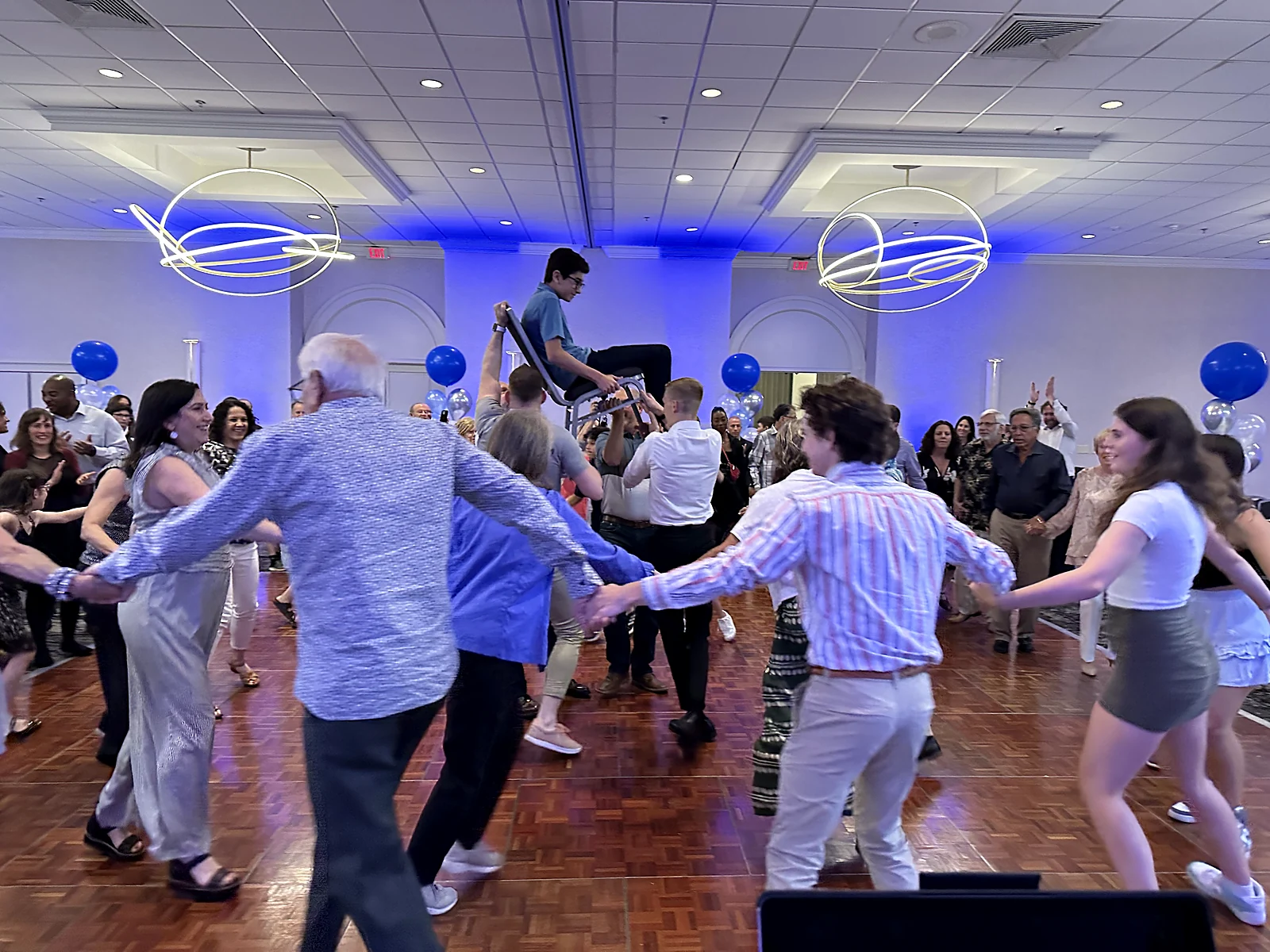 Guests lifted on a chair during a traditional hora at a bar mitzvah celebration