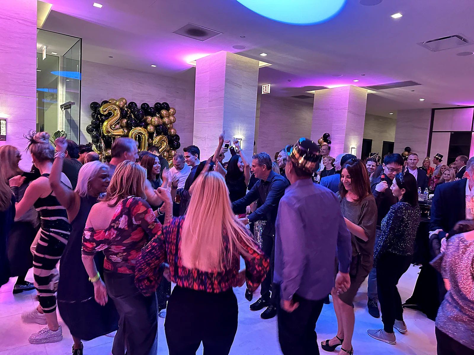 Guests celebrating New Year's Eve on a packed dance floor with gold balloons